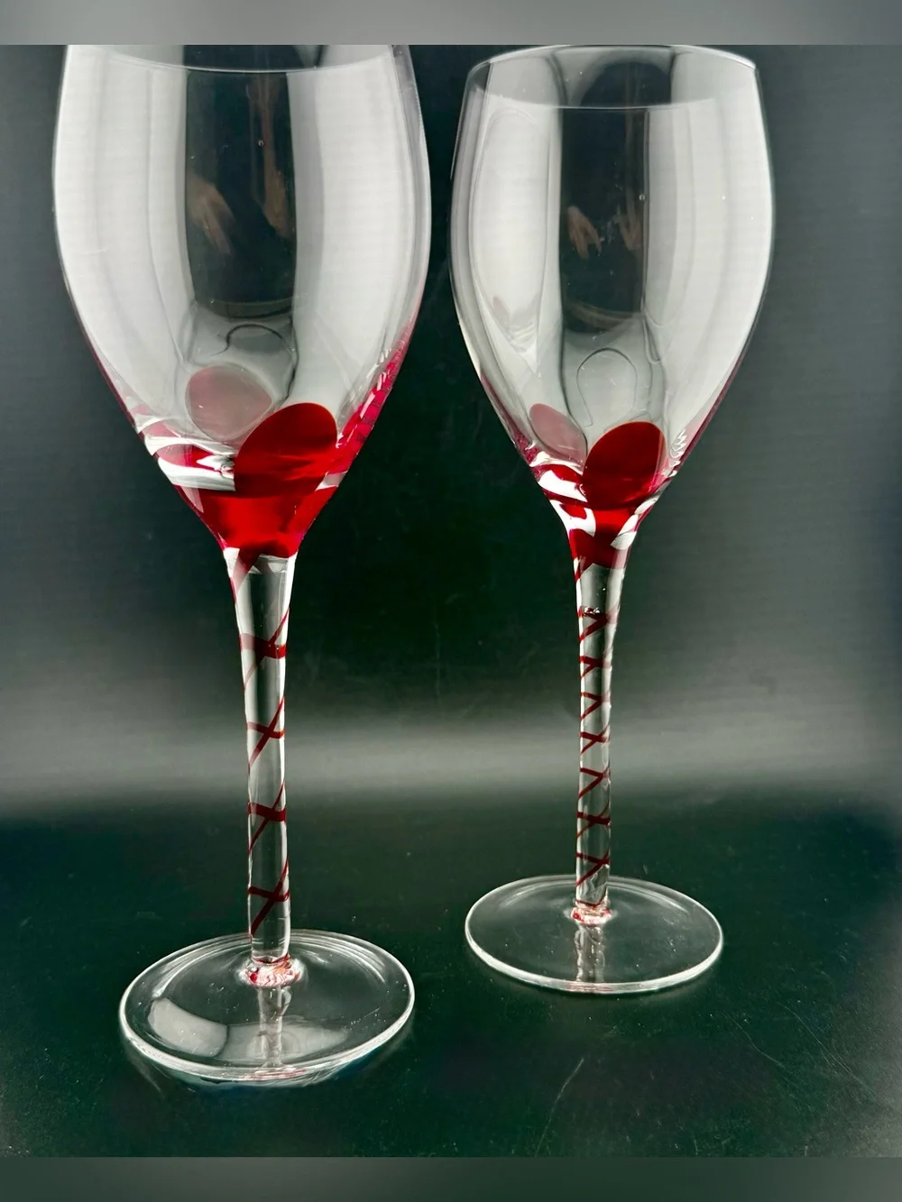 2 Pier 1, red ribbon swirl stem wine glasses, w/ a red swirl design on the stem.